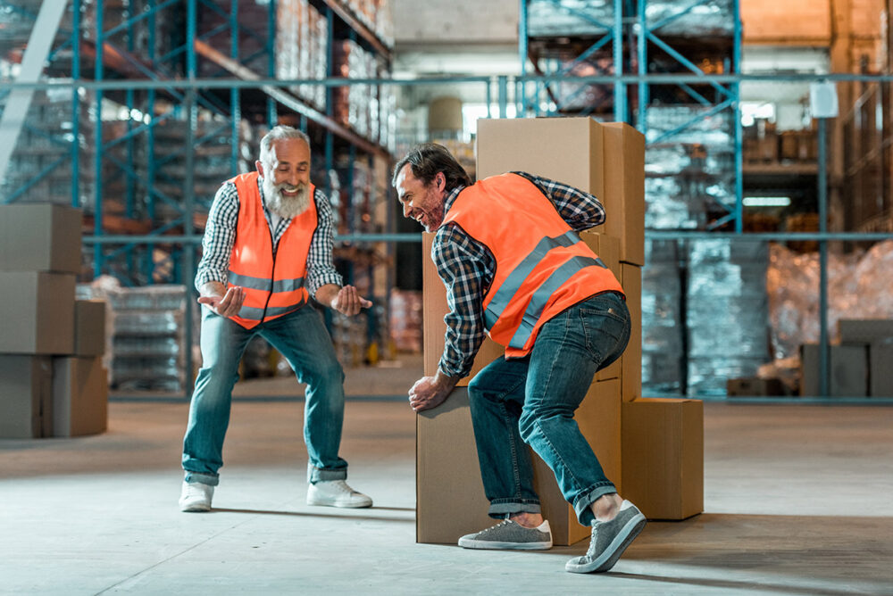 die-schutzprofis-stock-photo-warehouse-workers-moving-boxes-mehr-leistung